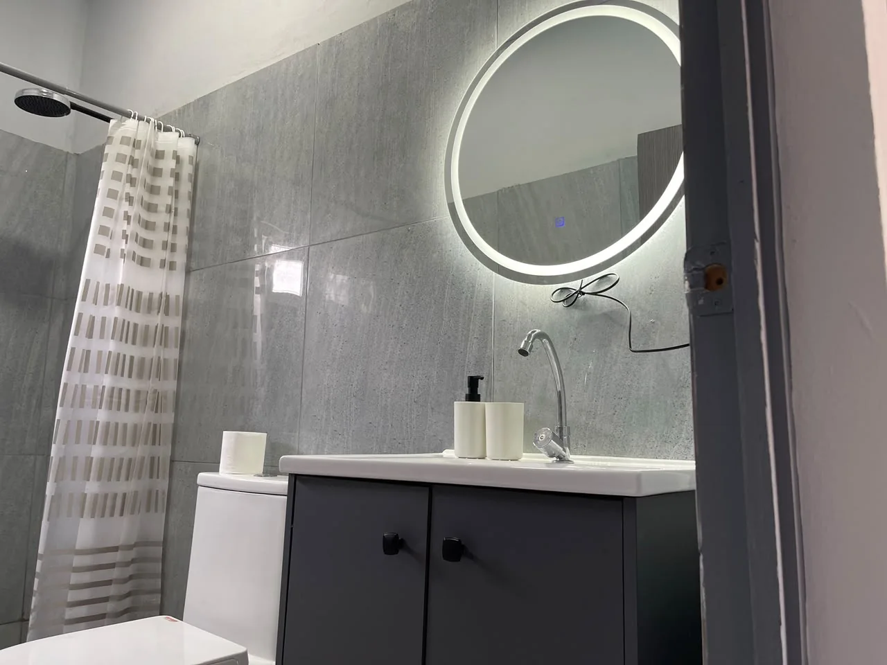 Baño con espejo circular iluminado